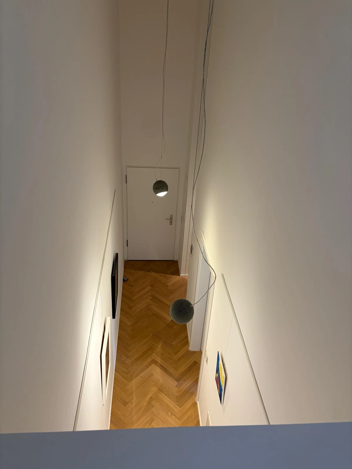 Blick von der Galerie nach unten auf den Flur mit Fischgrätparkett