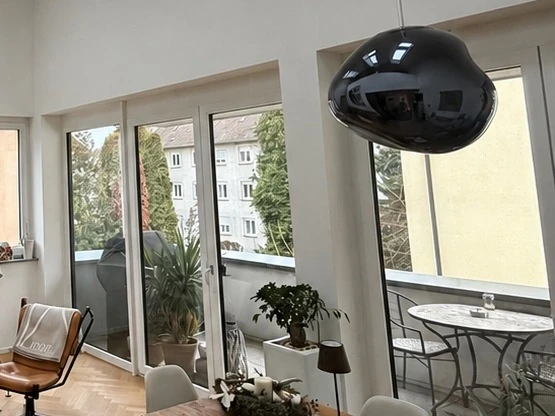 Südbalkon mit großer Fensterfront und Blick ins Wohnumfeld